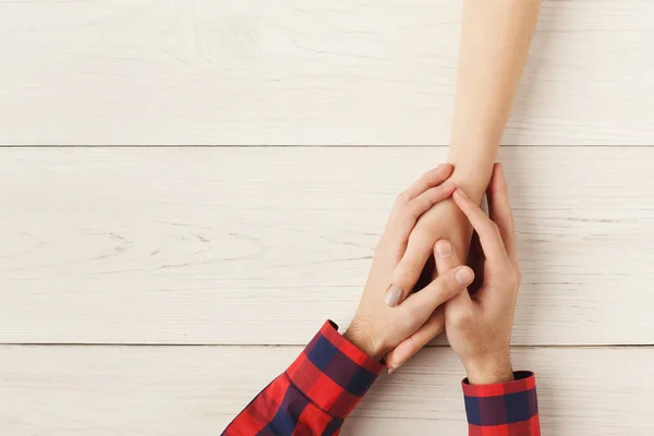 Bovenaanzicht van een mannelijke en vrouwelijke hand in hand — Stockfoto