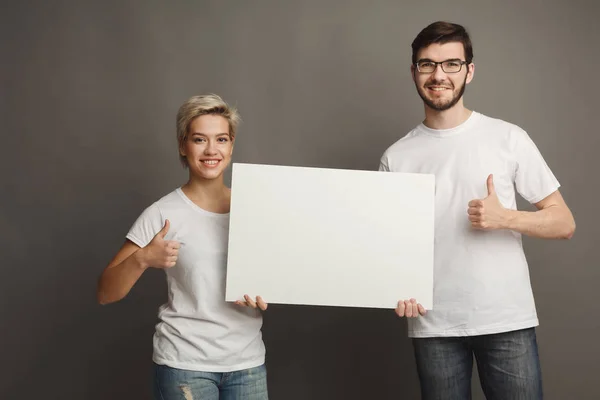 Junges Paar mit leerem weißen Banner — Stockfoto