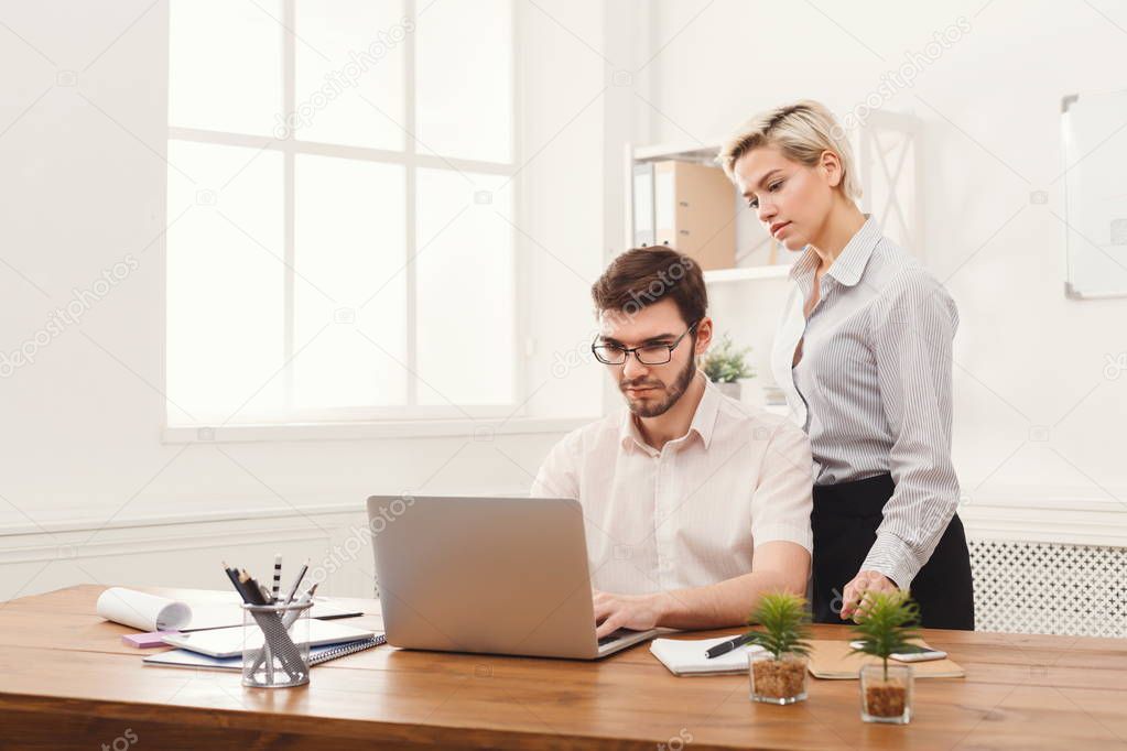 Couple of young colleagues working at modern office