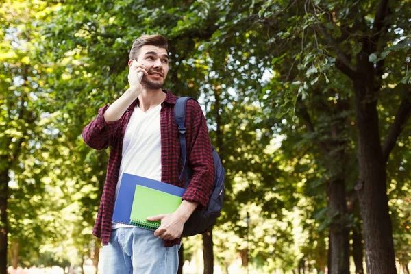 Junge Studentin spricht im Park mit Smartphone — Stockfoto