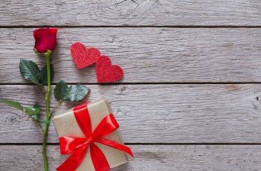 Sevgiliye arka plan kırmızı gül çiçek, kağıt kalp, rustik ahşap hediye kutusu ile