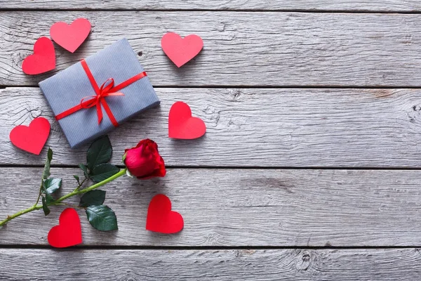 Valentinshintergrund, handgemachte Herzen, Rose und Geschenk auf Holz — Stockfoto