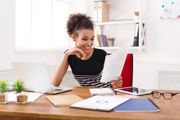 Zufriedene Geschäftsfrau liest Dokument am Schreibtisch im Büro — Stockfoto