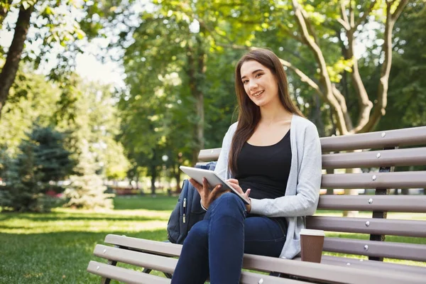 Gülümseyen kadın parkta dijital tablet kullanma — Stok fotoğraf