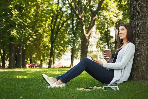 Mujer joven escuchando música en la hierba al aire libre —  Fotos de Stock