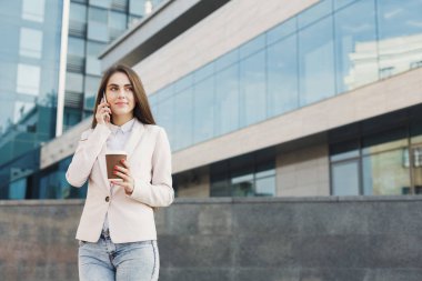 Cep telefonundan konuşurken kendine güvenen genç iş kadını portresi