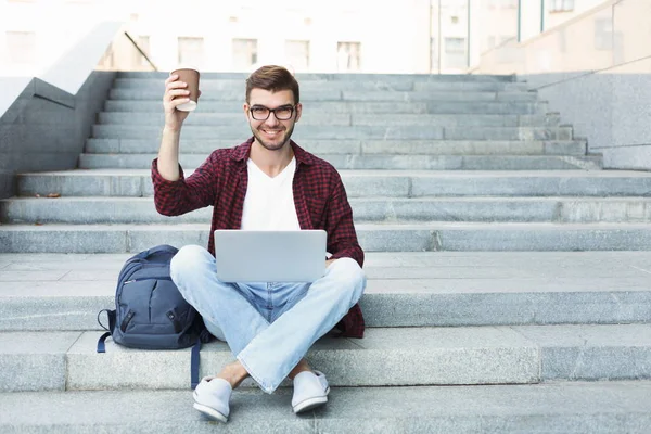 Estudiante trabajando en el ordenador portátil y beber café — Foto de Stock