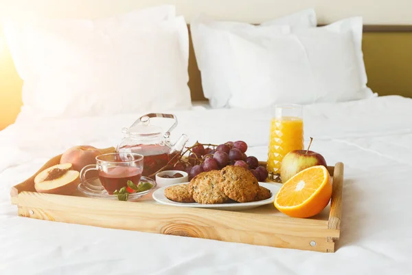 Завтрак подается в постели на деревянном подносе — стоковое фото