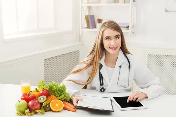 Femme nutritionniste travaillant sur tablette numérique — Photo