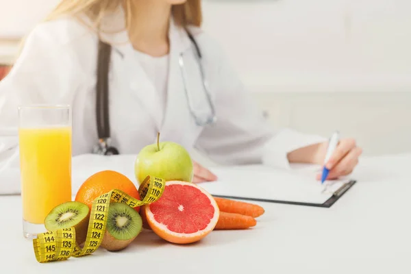 Nutritionist desk with fruit and measuring tape — Stock Photo, Image