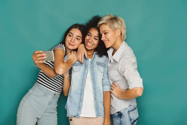 Trois femmes heureuses prenant selfie en studio — Photo