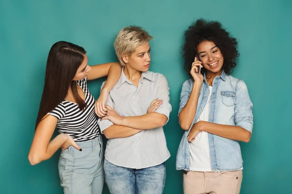 Meninas ouvindo seu amigo telefone celular falar — Fotografia de Stock