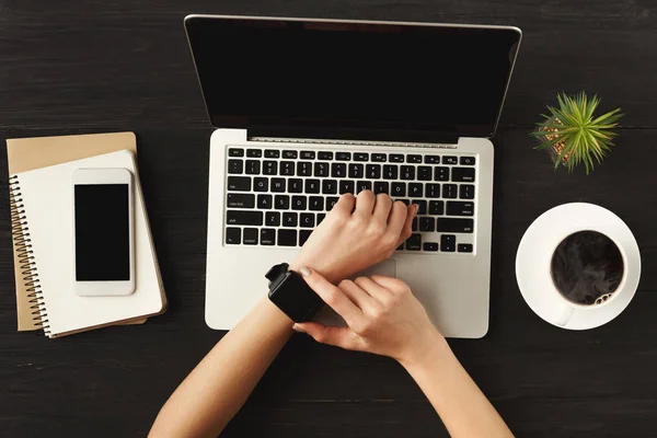 Womans hands and smart watch, top view