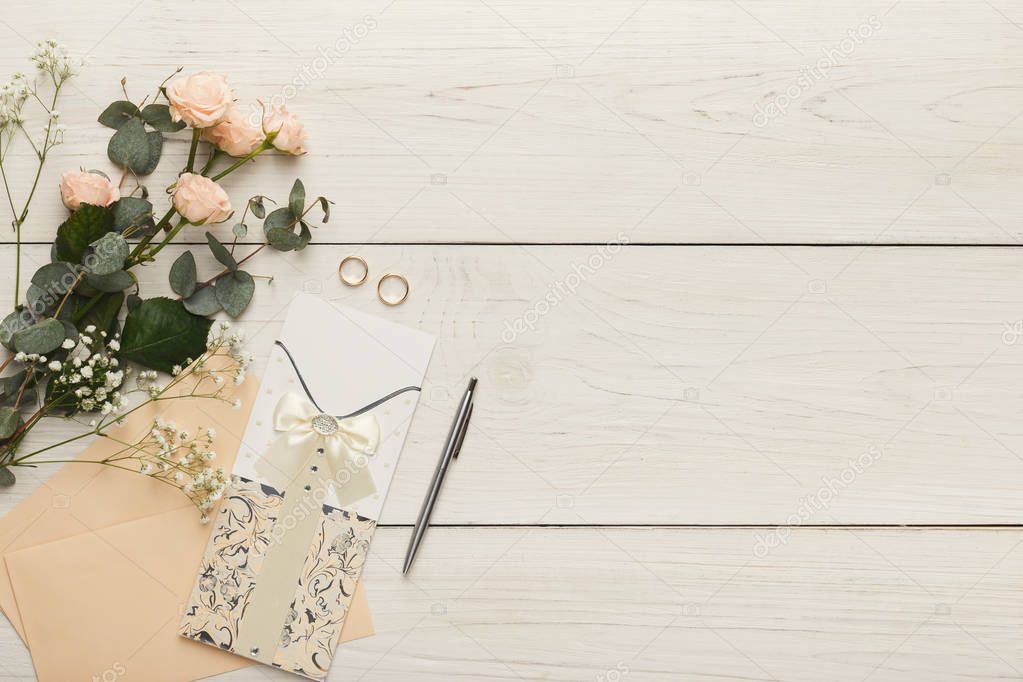 Wedding invitation cards and envelopes on white wooden 