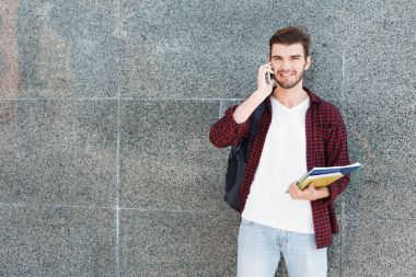 Telefon gri arka plan üzerinde konuşurken öğrenci