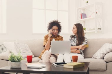 Kredi kartı ve dizüstü bilgisayar ile iki kadın online