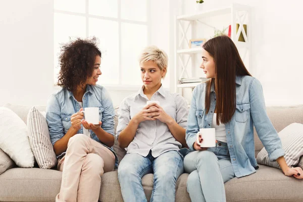 Trois jeunes amies avec café bavardant à la maison — Photo