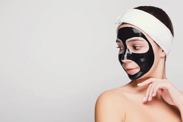 Chica joven con mascarilla negra purificante —  Fotos de Stock