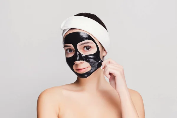 Jovem com purificação máscara facial preta — Fotografia de Stock