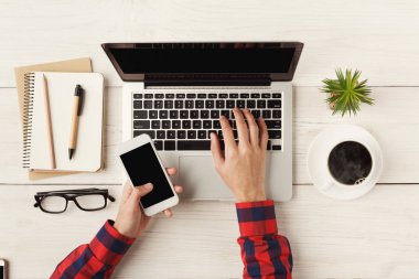 Laptop klavye ve smartphone, üstten görünüm tutan eller mans