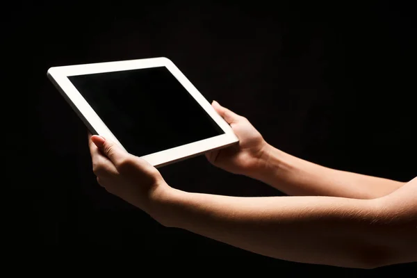 Mulher segurando tablet com tela em branco no fundo preto — Fotografia de Stock