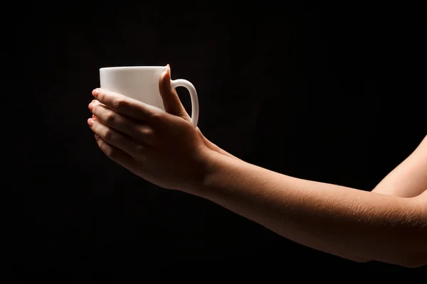 Frau mit weißer Kaffeetasse auf schwarzem Hintergrund — Stockfoto