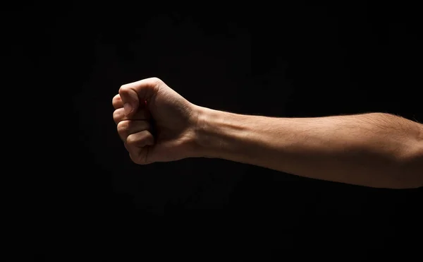 Hand gesture, man clenched fist, ready to punch isolated on black