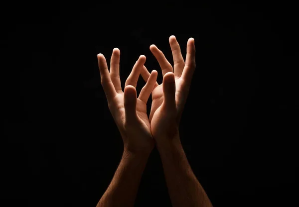Człowiek, utrzymując ręce cupped kształtu, wyłącznik na czarny — Zdjęcie stockowe