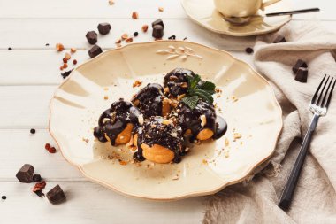 Çikolata sosu ve nane yaprakları ile Fransız profitroles