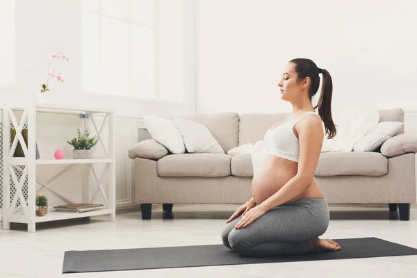 快乐怀孕的妇女训练瑜伽在英雄姿势 — 图库照片