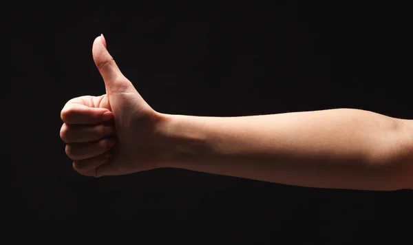 Caucásico mano femenina haciendo gesto pulgar hacia arriba, aislado en negro —  Fotos de Stock