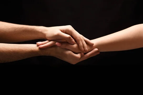Handen van man en vrouw in de liefde, geïsoleerd op zwart — Stockfoto