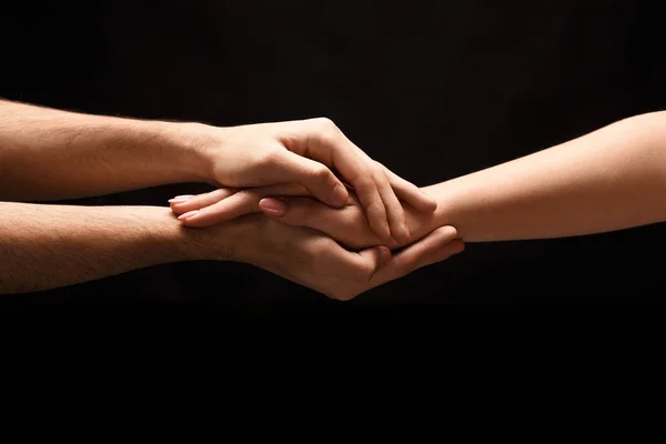 Manos de hombre y mujer enamorados, aislados en negro — Foto de Stock