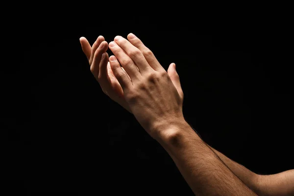 Mann hält Hände in Schröpfchenform, Ausschnitt auf schwarz — Stockfoto