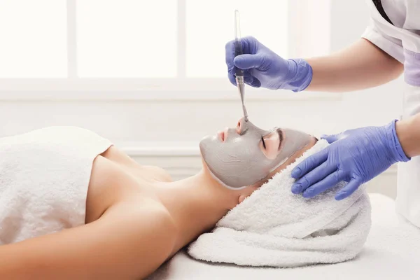 Mujer consigue máscara facial por esteticista en el spa —  Fotos de Stock