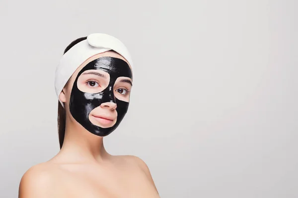 Jovem com purificação máscara facial preta — Fotografia de Stock