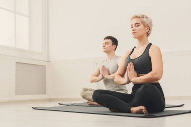 Genç çift padmasana içinde oturan yoga uygulamak