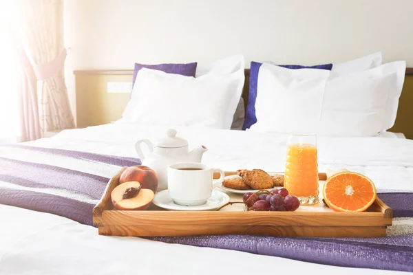 Breakfast served in bed on wooden tray — Stock Photo, Image