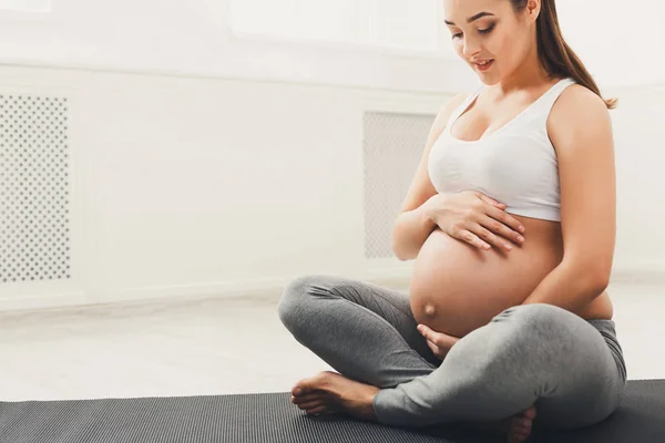 Mulher grávida acariciando sua barriga em casa — Fotografia de Stock