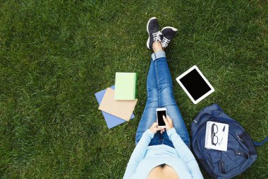 Kız ile smartphone çimenlerin üzerinde