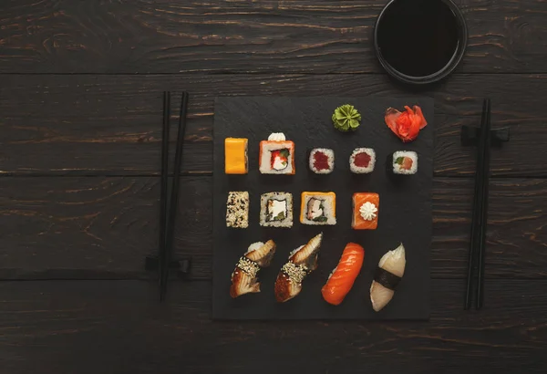 Суши и роллы в японском ресторане на черном дереве — стоковое фото