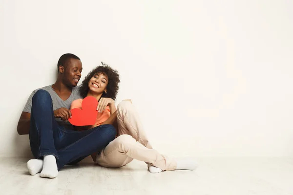 Heureux couple afro-américain amoureux tenant coeur de papier rouge — Photo