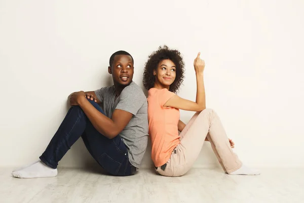 Couple afro-américain levant les yeux, assis sur le sol — Photo