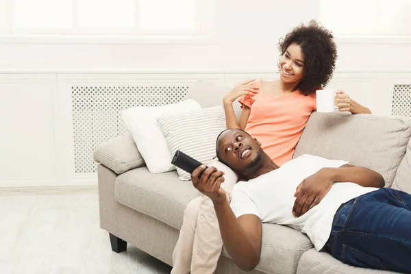 Sourire jeune couple afro-américain regarder la télévision à la maison — Photo