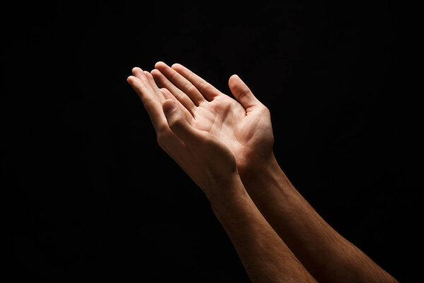 Man keeping hands in cupped shape, cutout on black