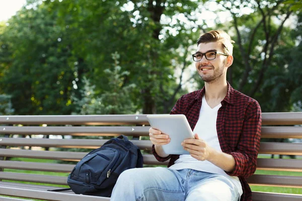 Sorrindo homem no parque com tablet oudoors — Fotografia de Stock