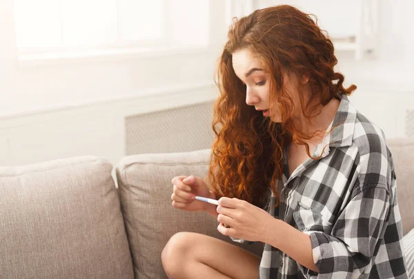 Verrast meisje het lezen van de resultaten van haar zwangerschap test — Stockfoto