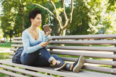 Açık havada Smartphone kullanan genç gülümseyen kadın