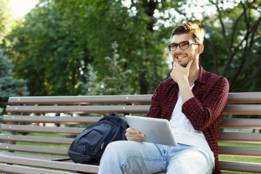 Park tablet oudoors ile gülümseyen adam