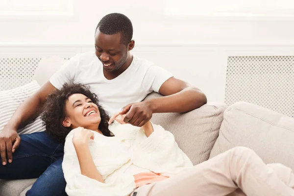 Sorrindo casal negro tendo descanso no sofá em casa — Fotografia de Stock